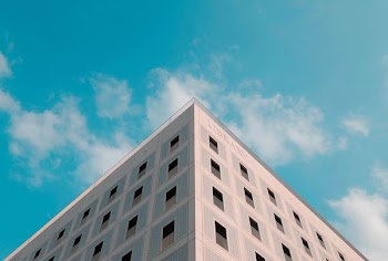 shallow focus photography of Library building under blue and white cloudy skies at daytime