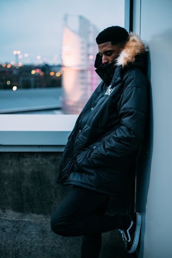 shallow focus photography of man in black and brown fur button-up coat