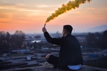 shallow focus photography of man sitting on platform