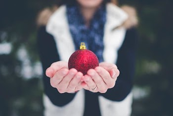shallow focus photography of person holding bauble