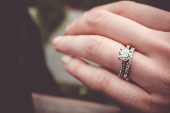 shallow focus photography of person wearing silver-colored ring