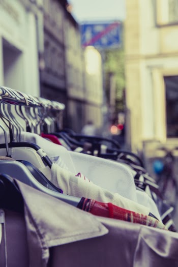 Shallow Focus Photography of Shirts Hang on Silver Clothes Rack Under Sunny Sky