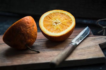 shallow focus photography of sliced lemon beside knife