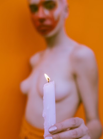 Shallow Focus Photography of Topless Woman Holding White Candle