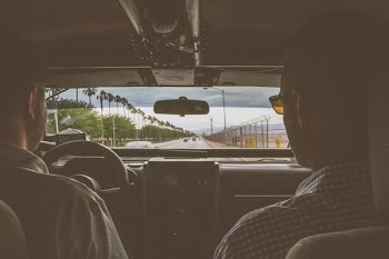 shallow focus photography of two man riding a car