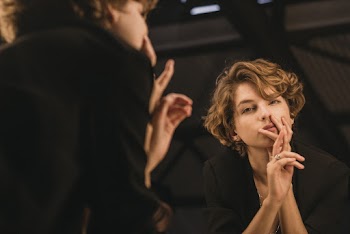 Shallow Focus Photography of Woman Holding her Chin Wearing a Black Top
