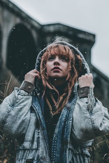 shallow focus photography of woman holding her hoodie