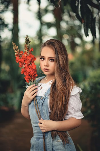 Shallow Focus Photography of Woman Holding Red Flowers
