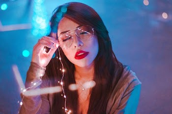 shallow focus photography of woman holding string lights