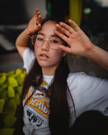 shallow focus photography of woman in white shirt raising hands
