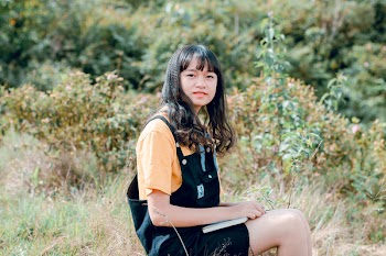 Shallow Focus Photography of Woman in Yellow Shirt and Black Dungaree
