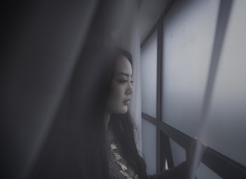 Shallow Focus Photography Of Woman Looking Out The Window