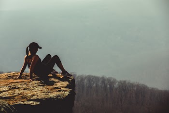 Shallow Focus Photography of Woman on Rock Formation