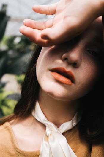 shallow focus photography of woman posing while covering right of hand