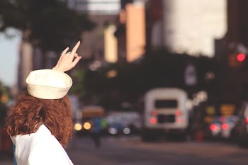 shallow focus photography of woman raising hand