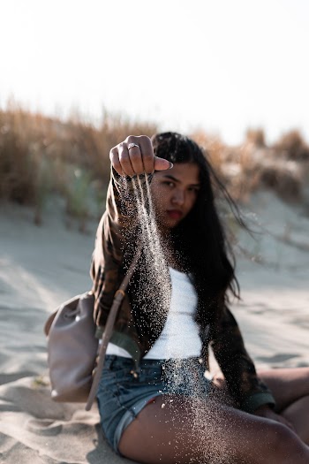 Shallow Focus Photography of Woman Sitting on Sand