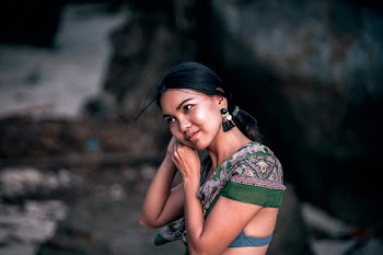 Shallow Focus Photography of Woman Standing on Stone While Fixing Her Earrig