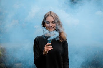 shallow focus photography of woman surrounded by smoke