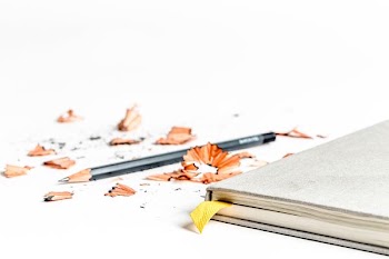 sharpened pencil near book