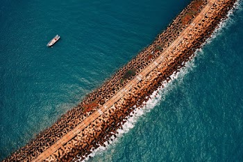 Ship on Body of Water Near Rock Formation