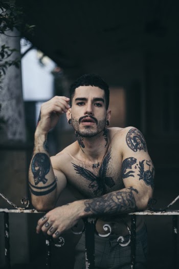 Shirtless Man Leaning On Gate