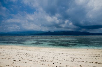 Shoreline and Brown Sand With Mountain Hill