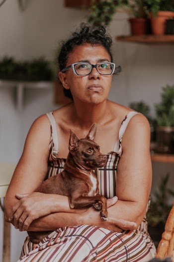 Short-coated Tan Puppy on Woman's Lap