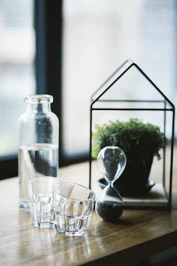 Shot Glasses and Hourglass on Brown Wooden Surface