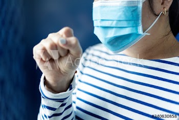 Sick woman wearing a face mask to stop the spread of coronavirus