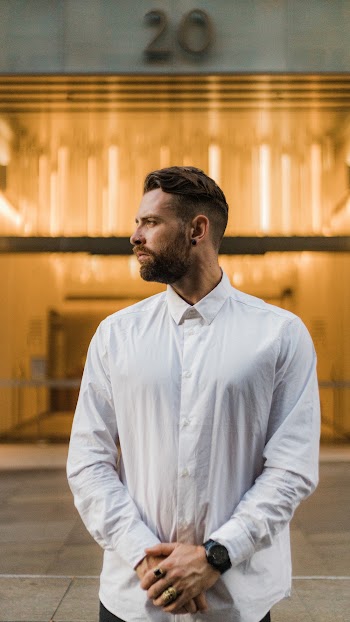 Side View Of A Man Wearing White Buttoned-up Dress Shirt Standing In Front Of Building