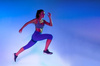Side view of athlete training with blue background Free Photo