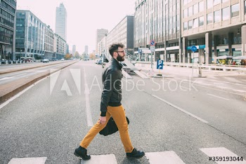 Side view of businessman crossing street in city