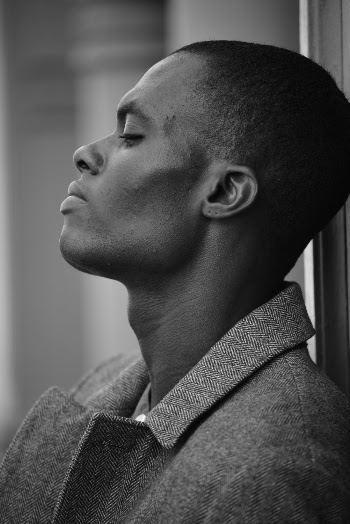 Side View Photo Of A Young Man In A Tweed Jacket In Grayscale