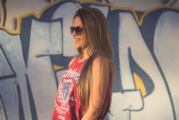 Side View Photo of Smiling Woman in Red Tank Top and Sunglasses Near Graffiti Wall