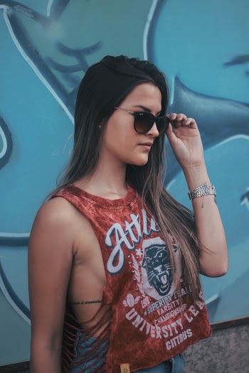 Side View Photo of Woman in Red Tank Top and Sunglasses Standing Near Graffiti Wall