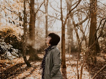 Side View Photo of Woman in the Middle of the Woods Looking up