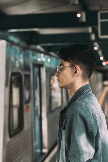 Side View Portrait Photo of Man Standing on Subway Platform by Train