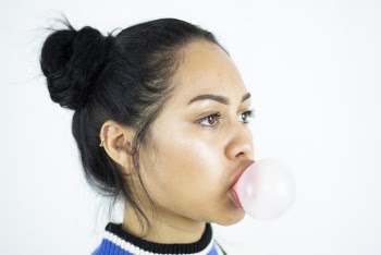 Side View Portrait Photo of Woman Making Bubble Using Chewing Gum