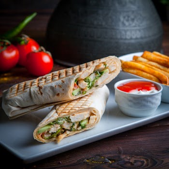 Side view shawarma pita roll with chicken and fried potatoes Free Photo