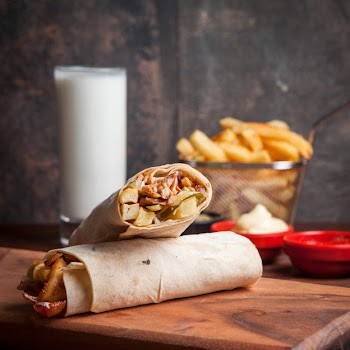 Side view shawarma with fried potatoes and ayran and mayonnaise in board cookware Free Photo