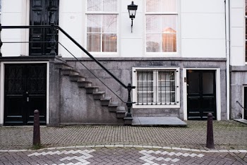 Sidewalk Entrance to a White Building