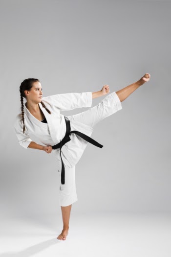 Sideways karate woman in traditional white kimono on white background Free Photo