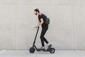 Sideways man riding e-scooter Free Photo