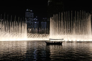 Silhouette of a Boat on a Body of Water With Fountain