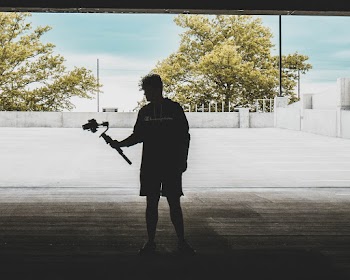 Silhouette of a Man Carrying a Camera