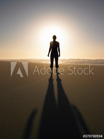 silhouette of a man walking on the beach