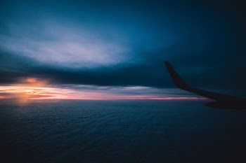 silhouette of airplane flying through sky