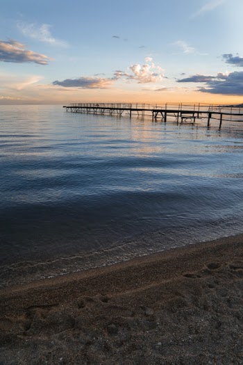 Silhouette of Boardwalk Under Cloudy Skies Shot from Beach