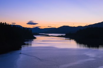 silhouette of body of water near mountain
