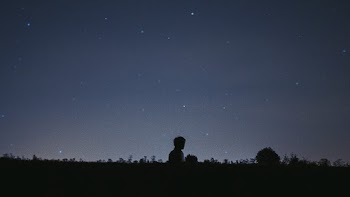 Silhouette of Boy Under Black Sky